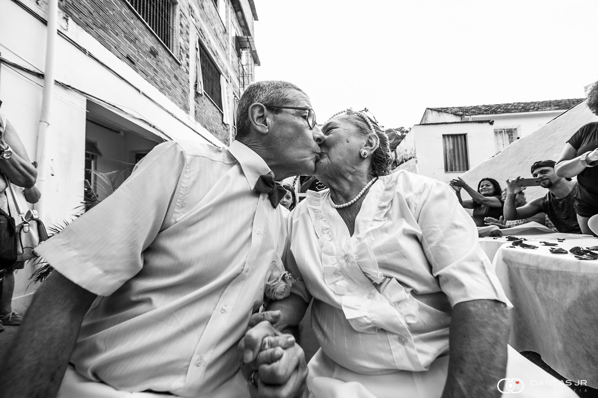 casal de noivos idosos se beijando no altar