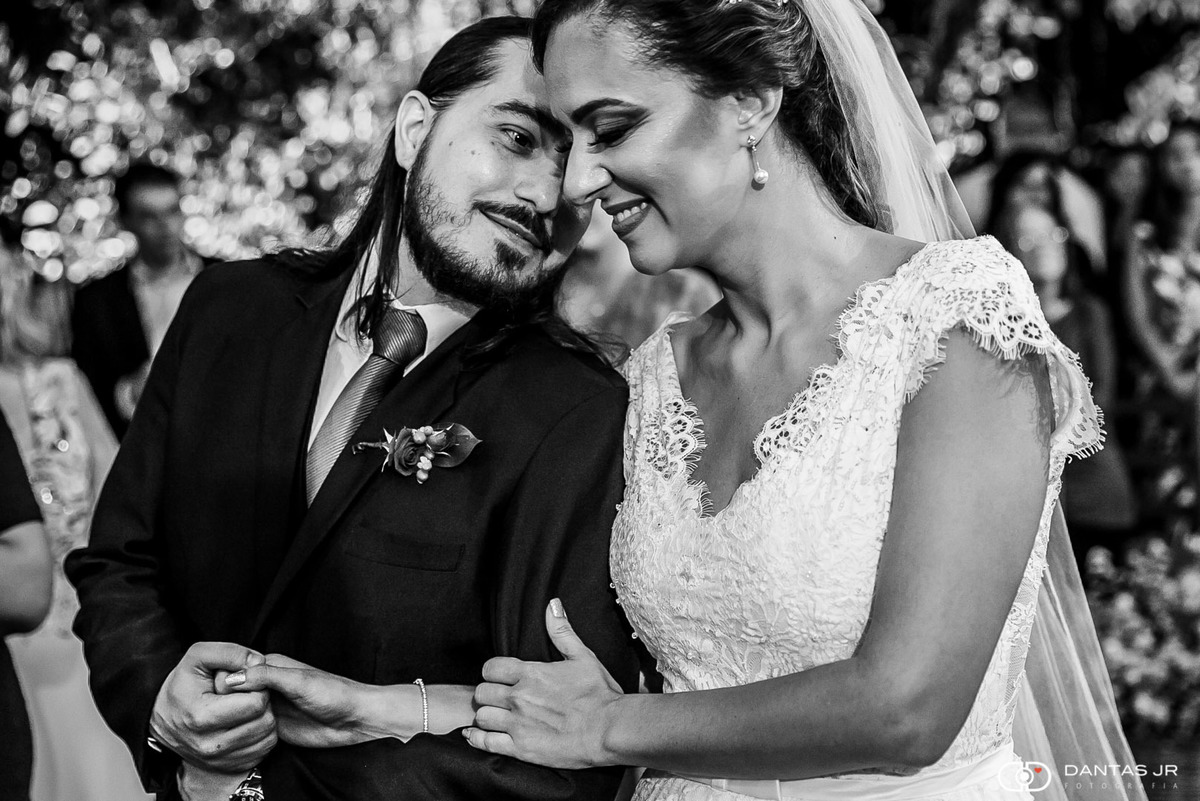 noivo apaixonado admirando noiva e fazendo carinho no altar durante casamento