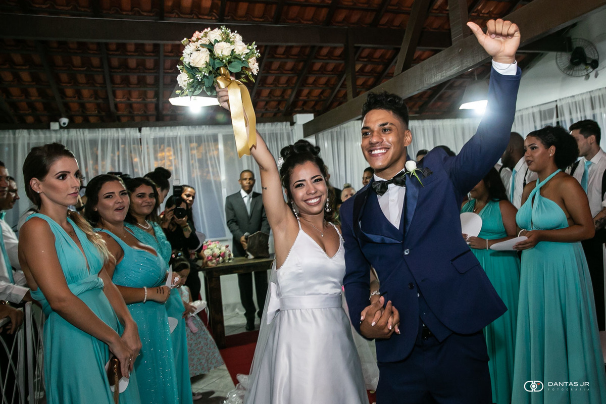 noivos felizes com braços pra cima