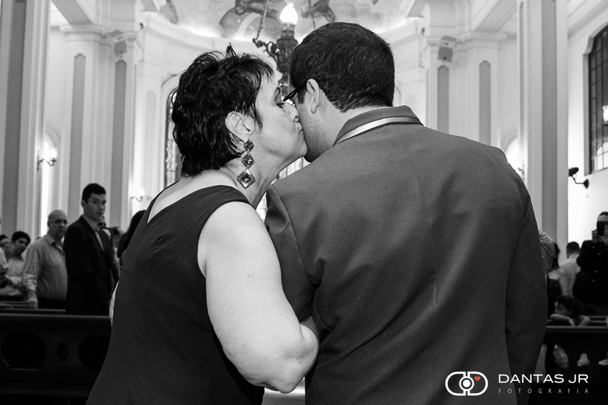 mãe do noivo dando um beijo emocionada pouco antes da noiva entrar no altar da igreja no dia do casamento