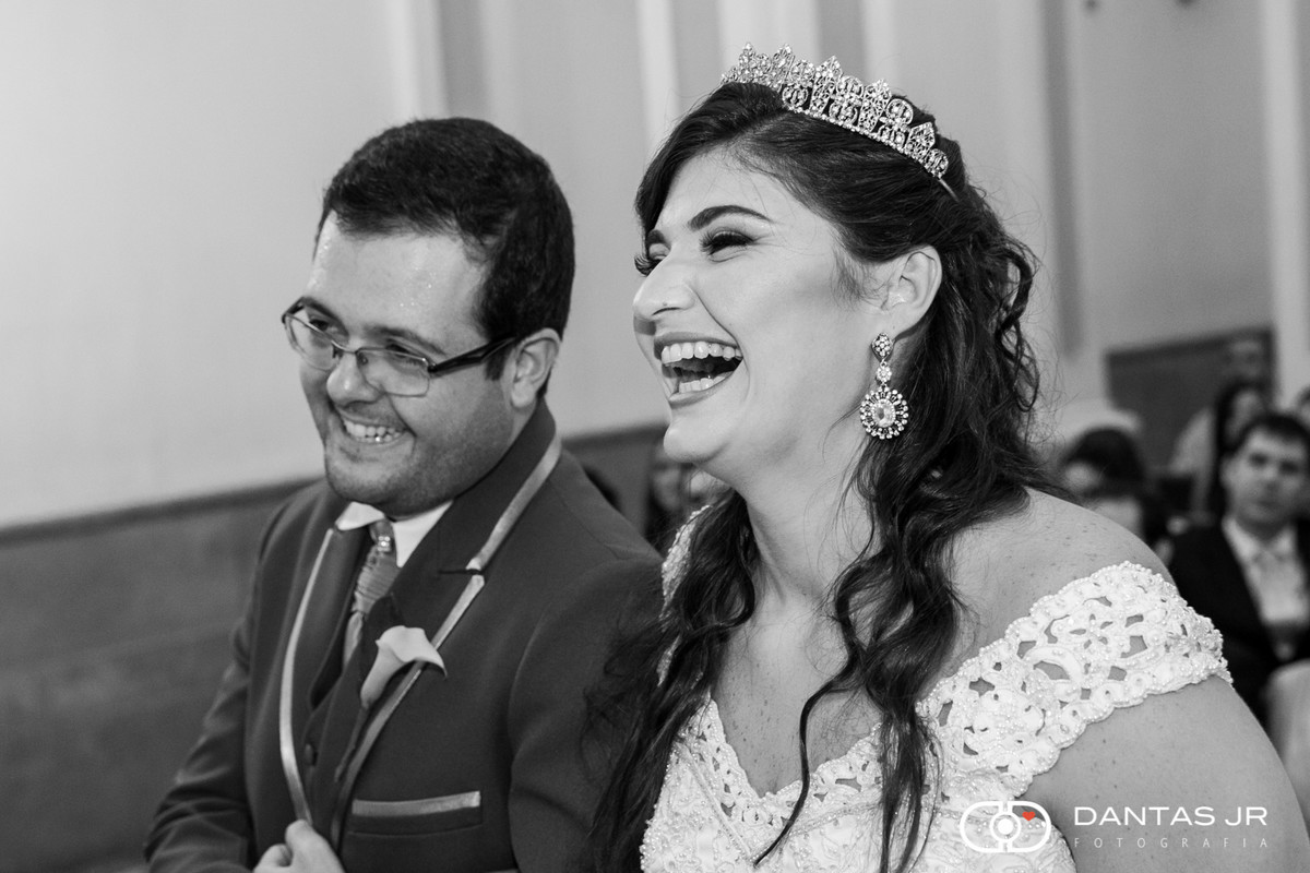 Noivos gargalhando no altar descontraídos durante cerimônia de casamento