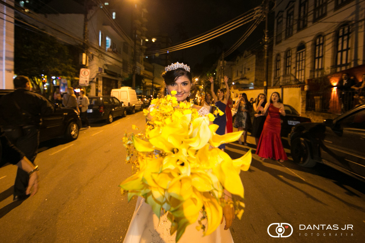 Noiva jogando bouquet amarelo no meio da rua para suas convidadas