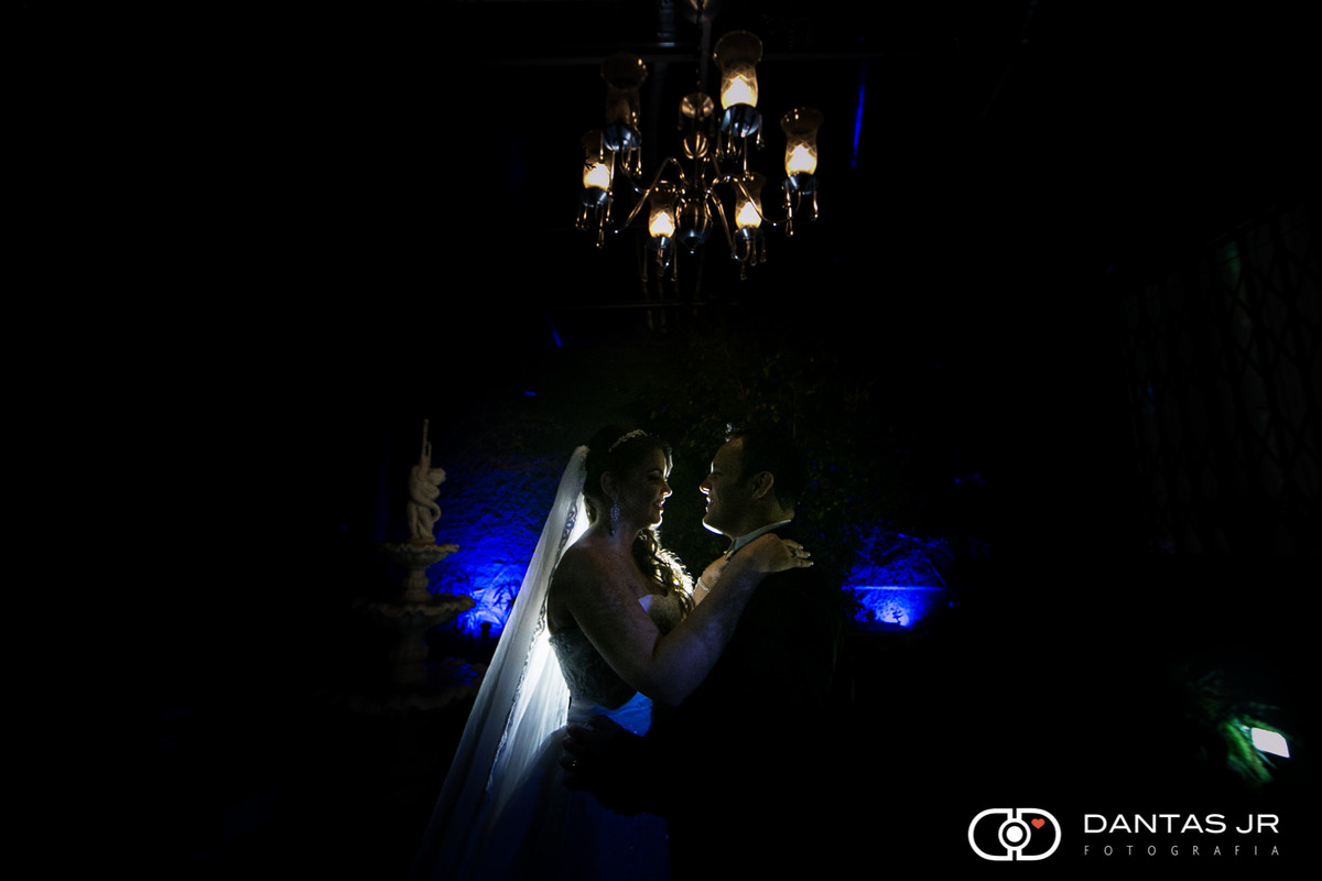casal de noivos na penumbra com olhares apaixonados trocando carinhos no Espaço Luz