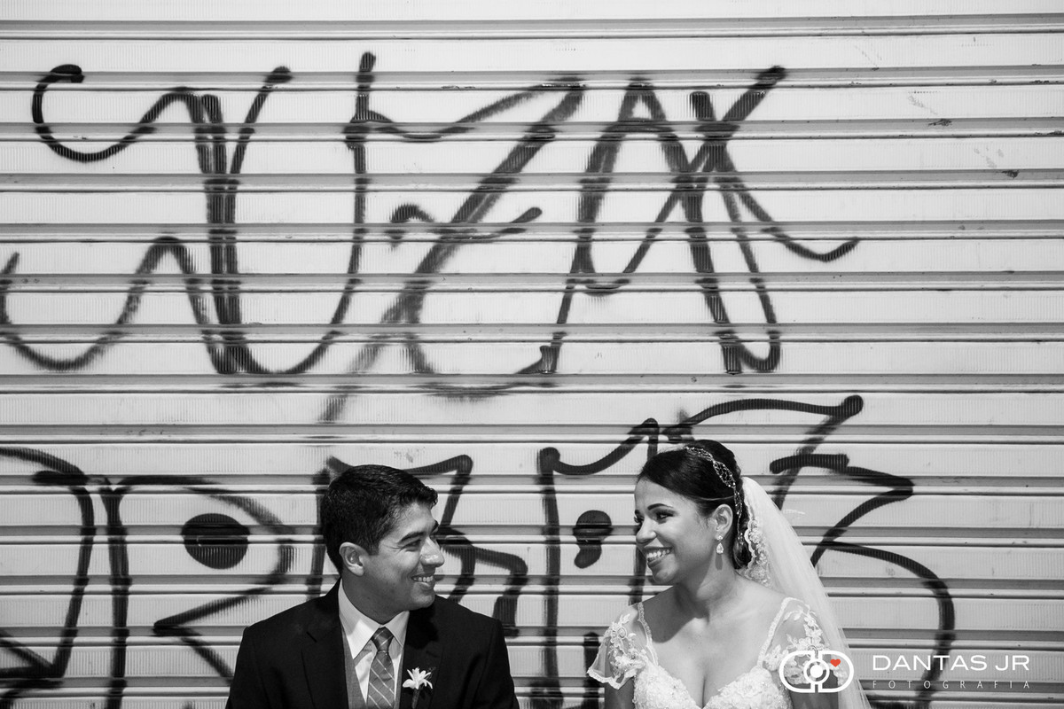 Casal de noivos apaixonado em frente a portão grafitado no Centro do Rio de Janeiro