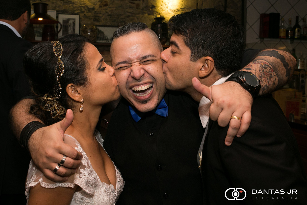 casal de noivos apaixonados, felizes e agradecidos beijando o melhor fotógrafo de casamentos do Rio de janeiro Dantas Jr