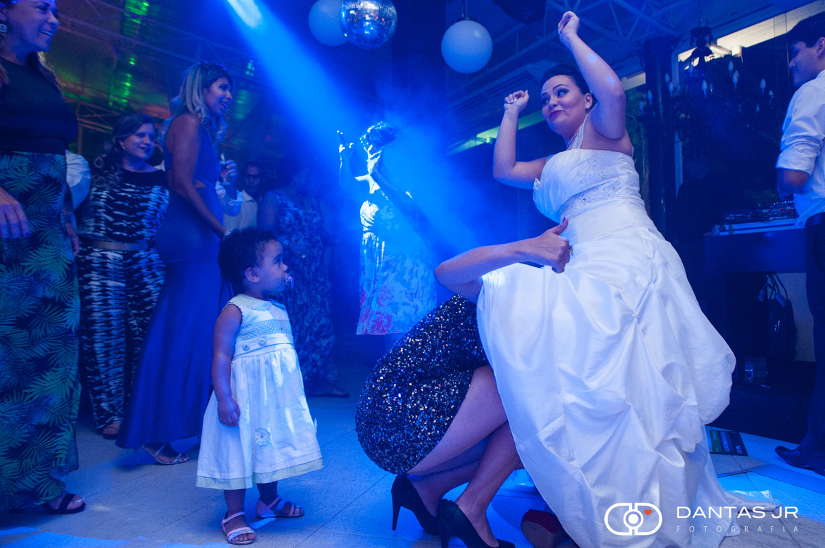 festa de casamento com noiva dançando e convidado entrando debaixo do vestido