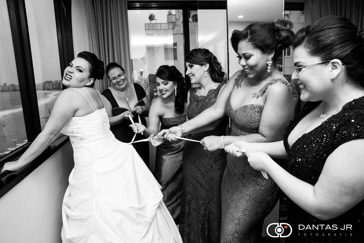 madrinhas marrando o vestido da noiva fazendo força durante o making of pelo fotografo dantas jr