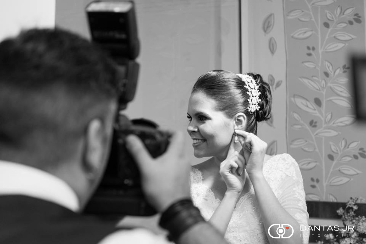 noiva colocando brinco e sendo fotografada pelo Dantas Jr