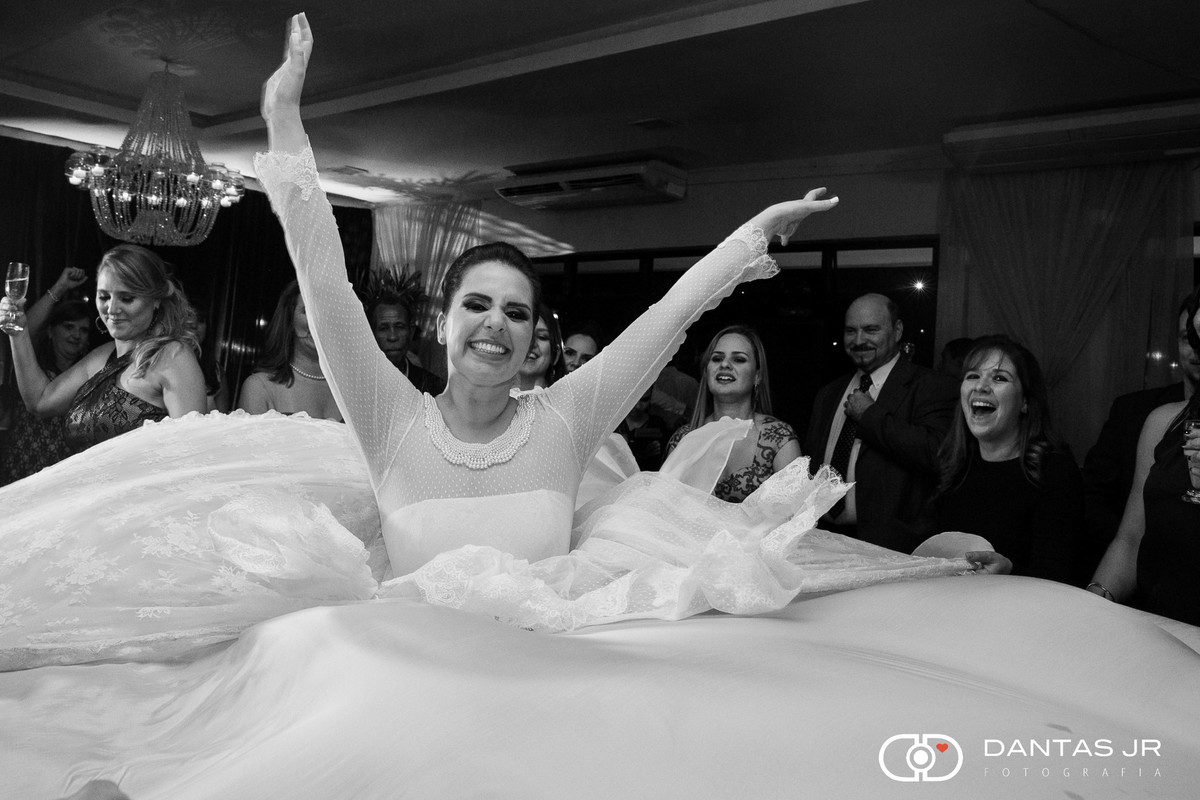 Noiva rodando com madrinhas segurando barra do vestido sorrindo feliz em festa de casamento no Iate Clube de Icaraí em Niteroi clicado pelo fotografo Dantas Jr.