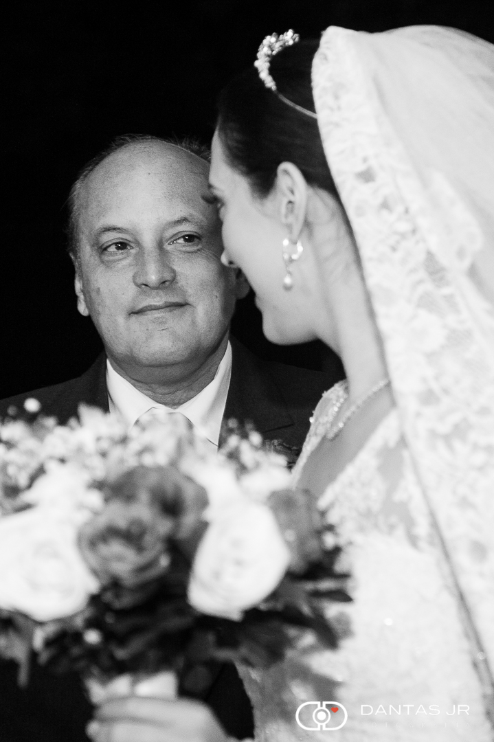 pai admirando filha vestida de noiva e emocionado