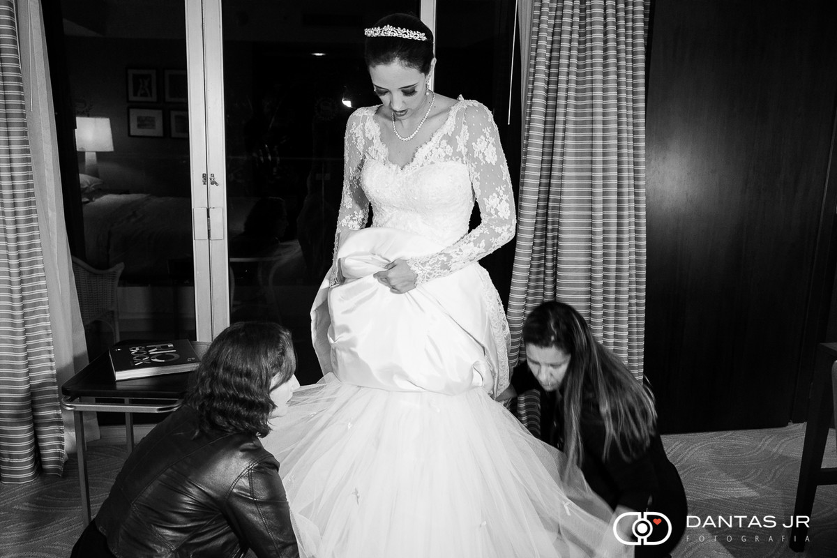 noiva colcando vestido sendo ajudada por mãe e maquiadora no Hotel Sheraton no Rio de Janeiro clicada por Dantas Jr