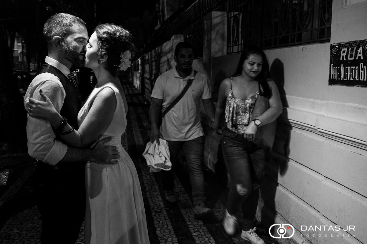 Casal namorando na rua enquanto pessoas passam