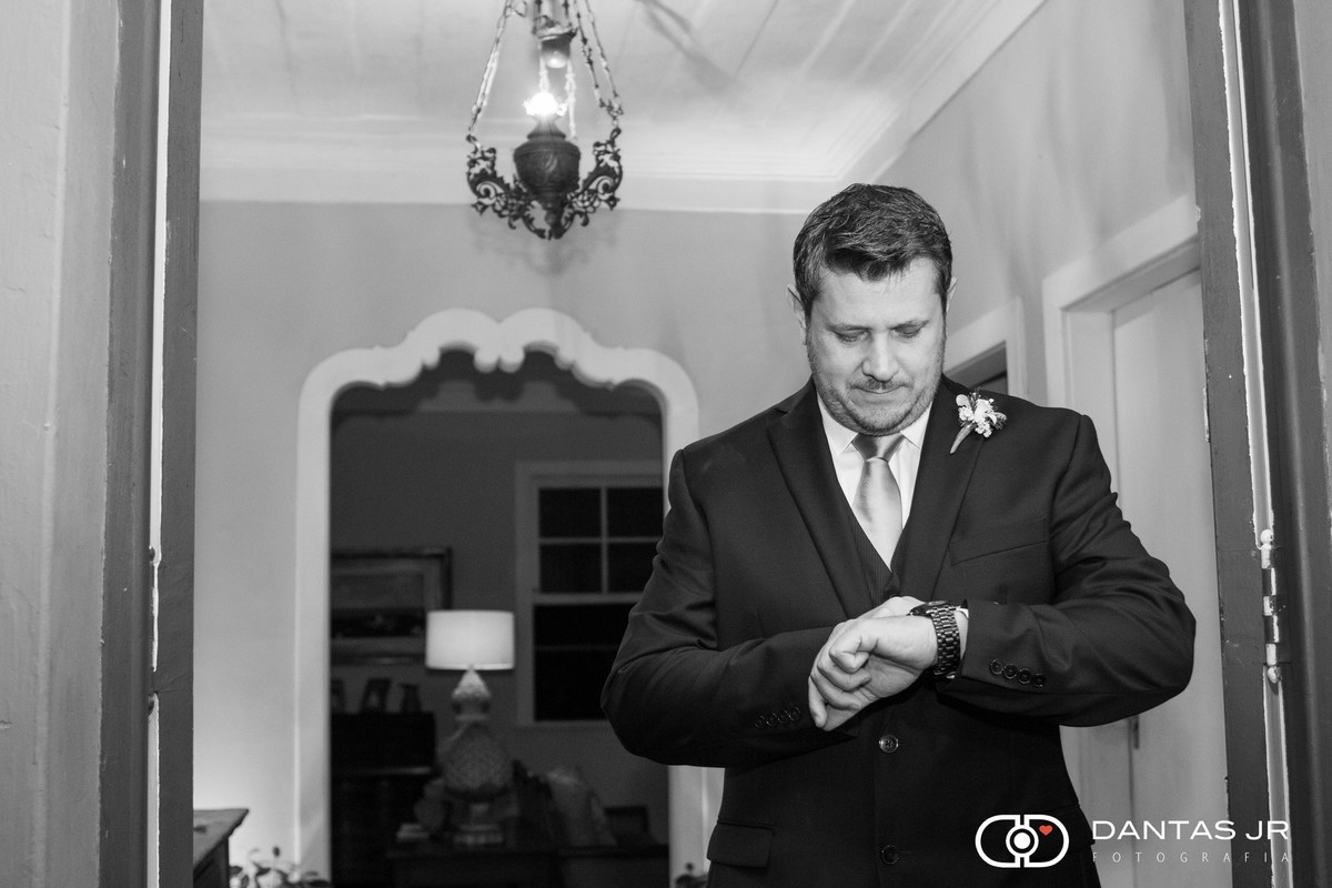 noivo apreensivo olhando o relógio e conferindo as horas antes da cerimônia