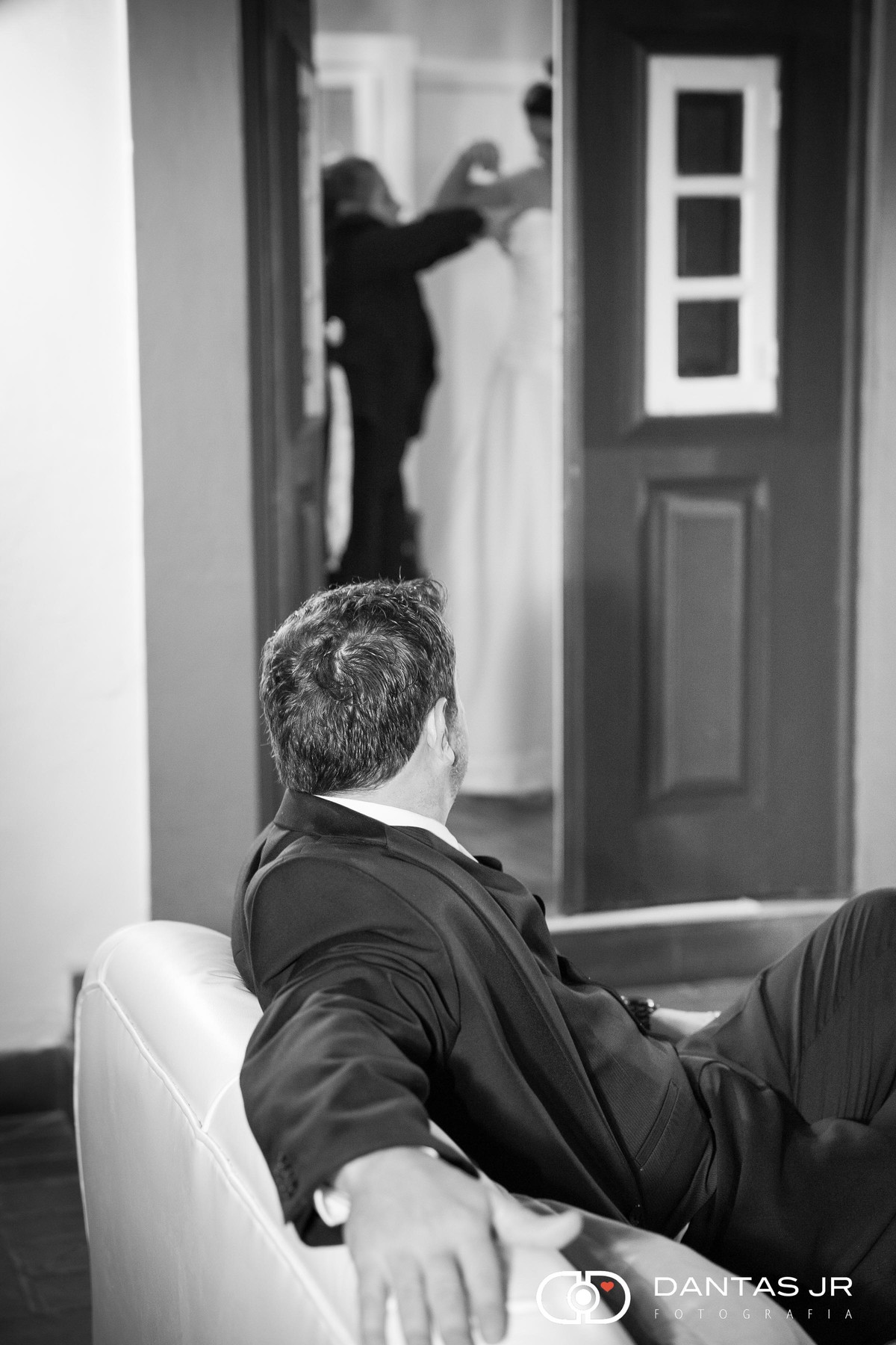 noivo olbservando noiva se arrumando por fresta de porta