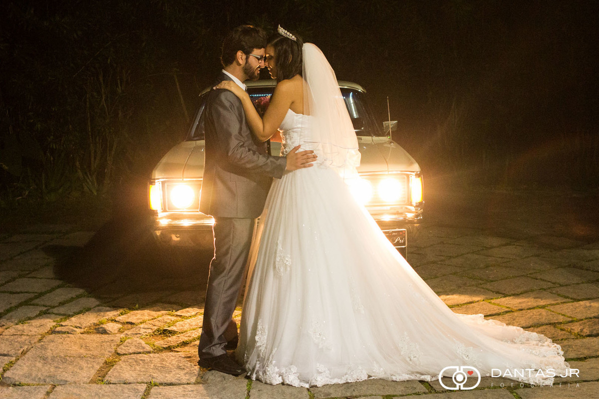 noivos se beijando na frente de carro antigo