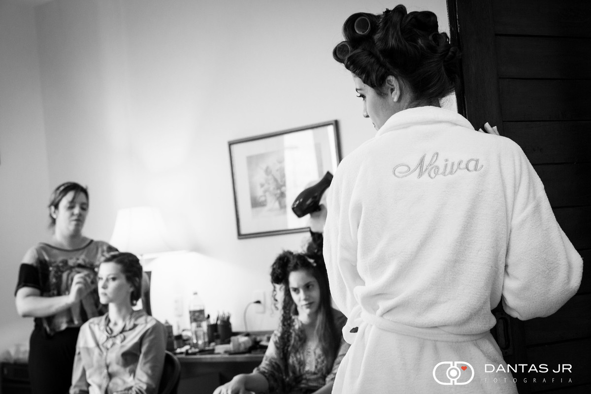 noiva na porta de roupão olhando madrinha se arrumar