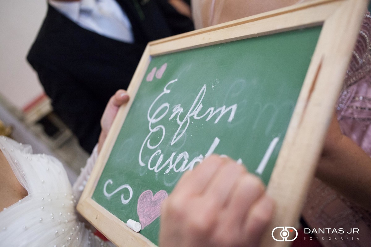noiva escrevendo placa de enfim casados no altar da igreja