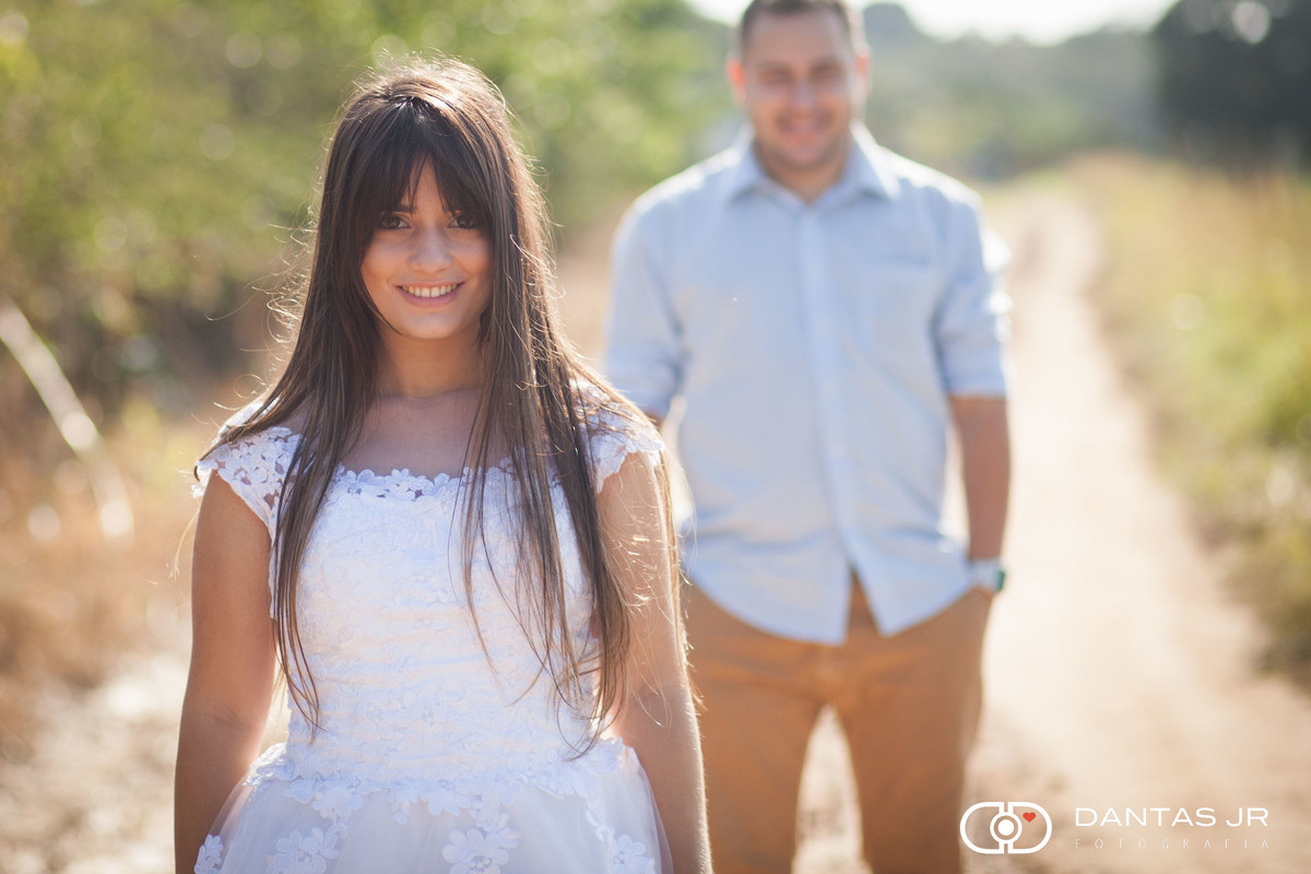 noiva em trash the dress parada na frente do noivo que a aobserva