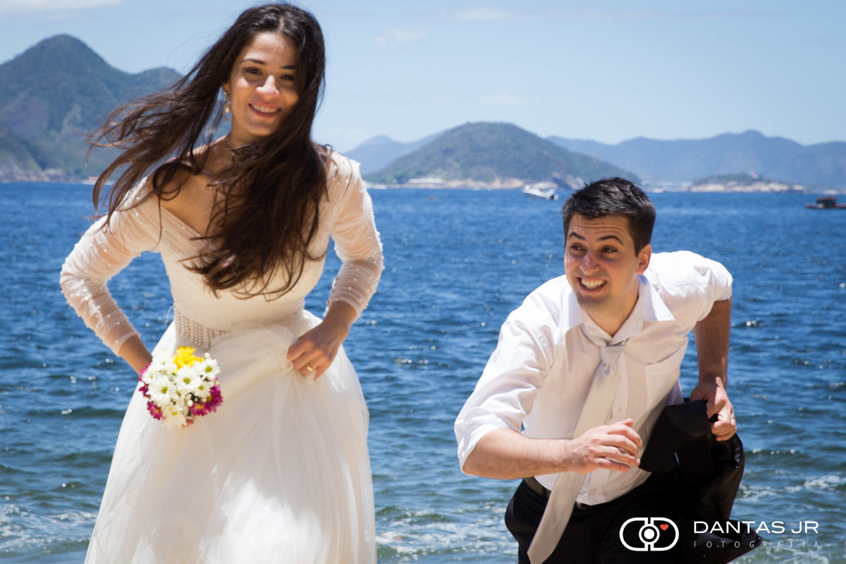 noivo correndo atras de noiva em trash the dress na praia