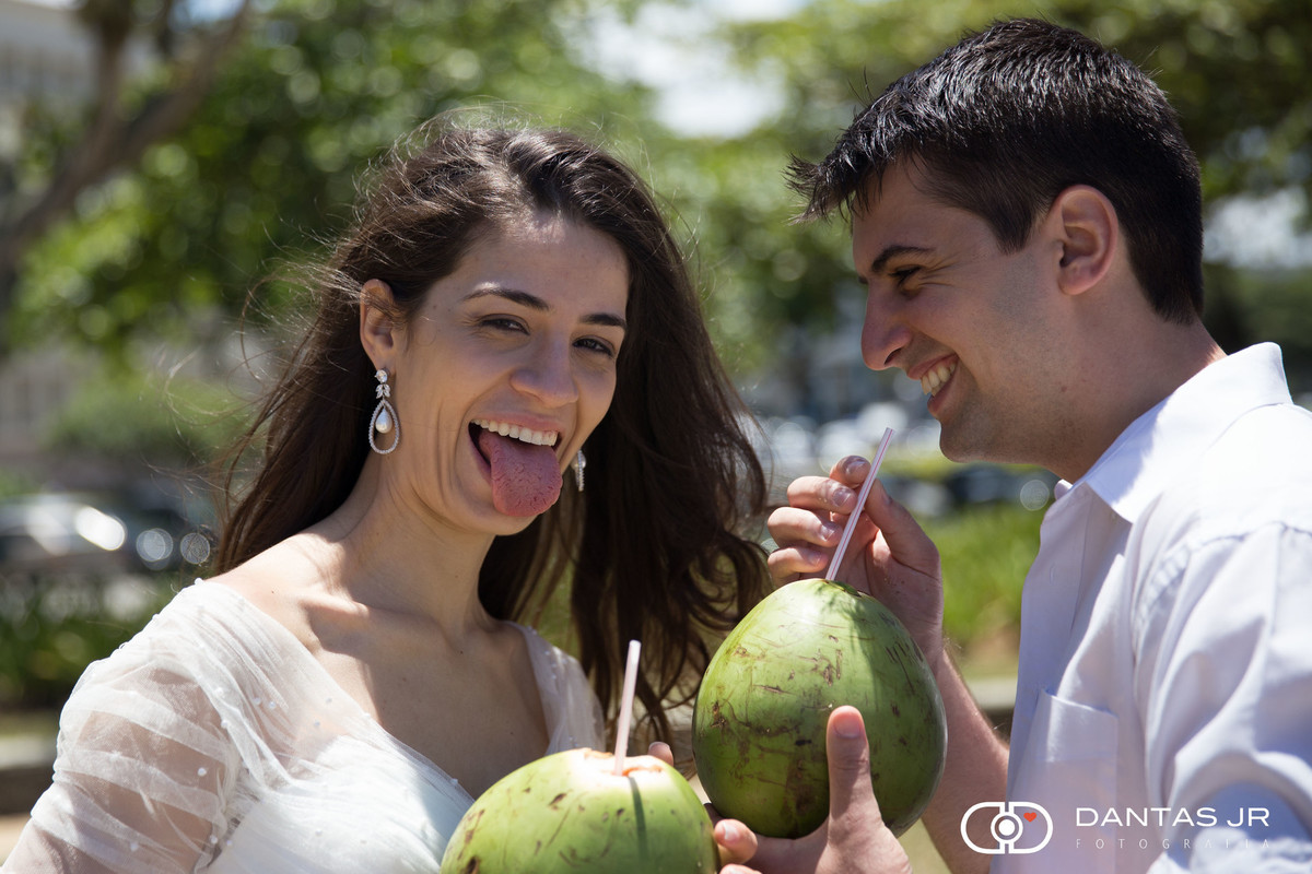 noivos bebendo agua de coco em trash the dress e noiva fazendo careta