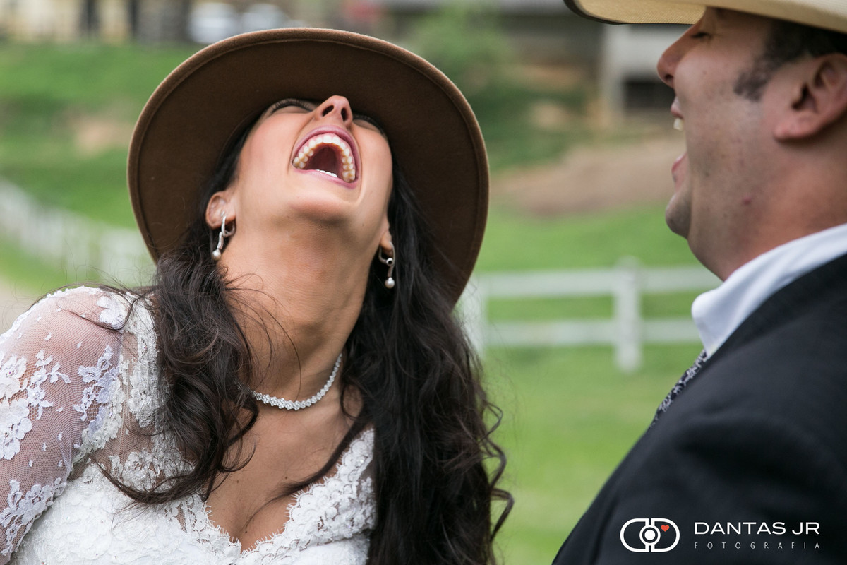 noiva com chapeu de cauboi rindo muito em trash the dress