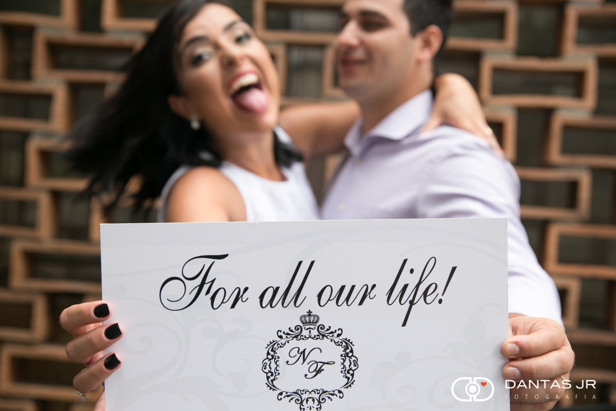 casal em trash the dress segurando placa escrita for all our life