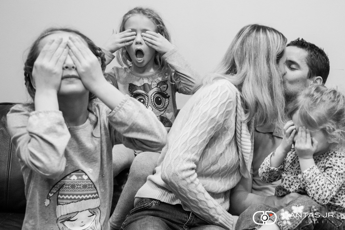 crianças fechando os olhos enquanto pais se beijam