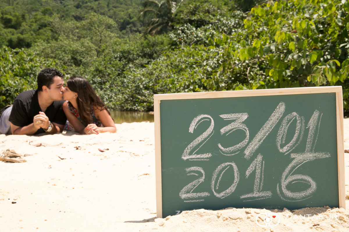 save the date de casal com placa fincada na areia