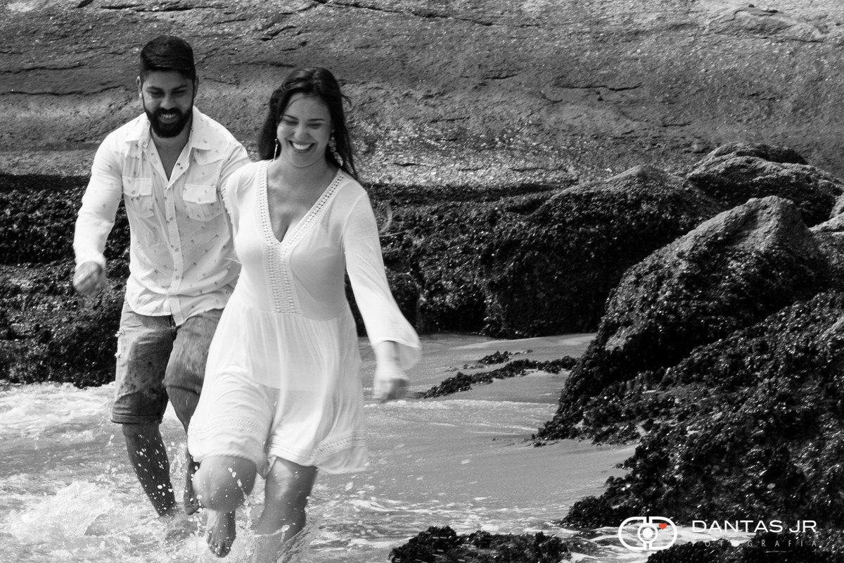 casal correndo entre pedras na praia vermelha no rio de janeiro na urca rio de janeiro