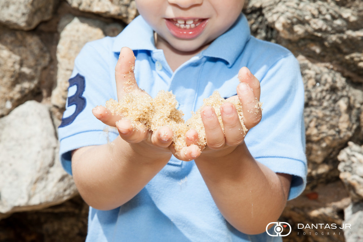 mãozinha de criança pegando areia