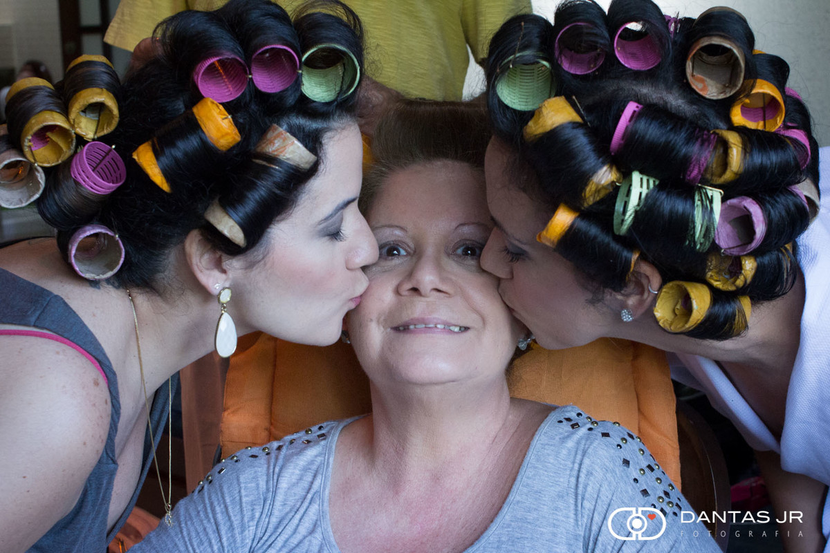 mãe sendo beijada por duas filhas durante making of