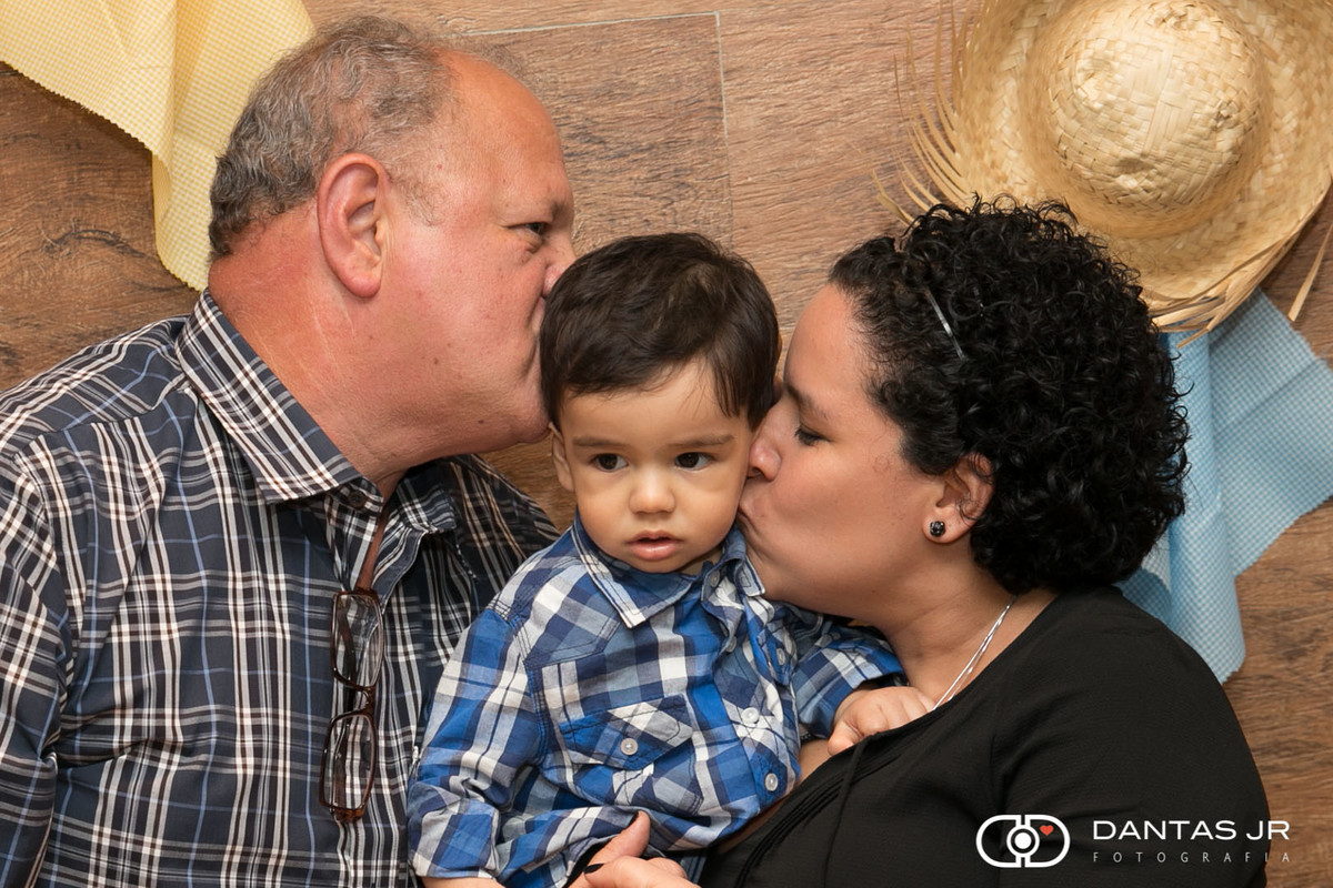 pai e mãe beijando criança