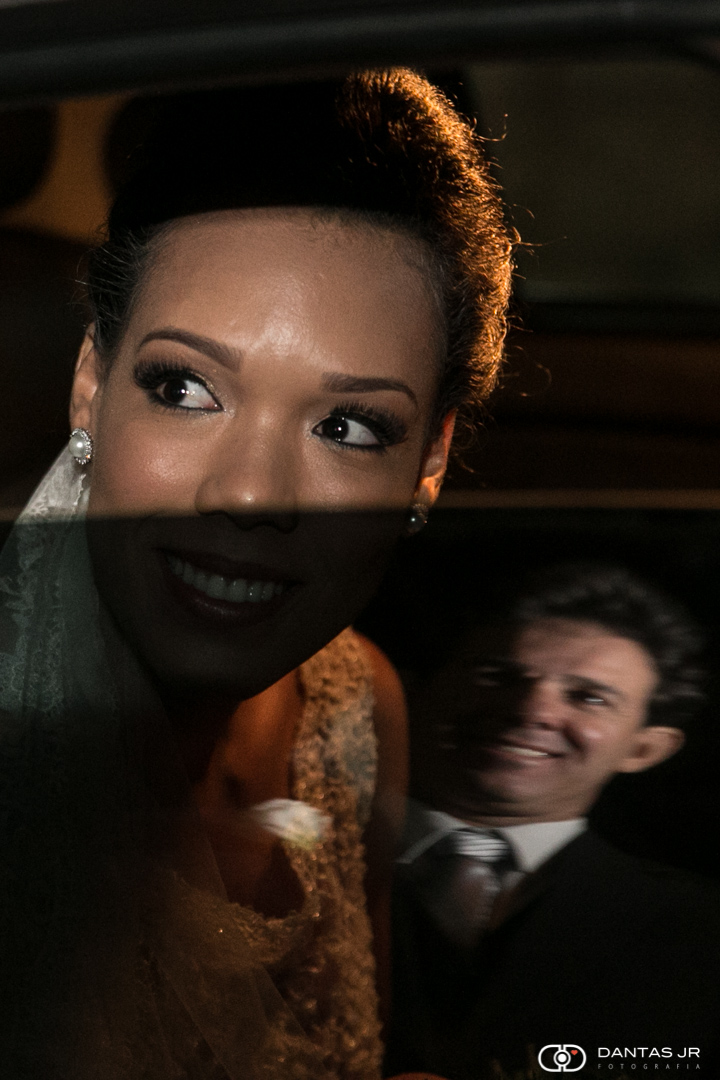 Noiva antes de entrar na igreja sendo vista pelo irmão pelo reflexo no vidro do carro