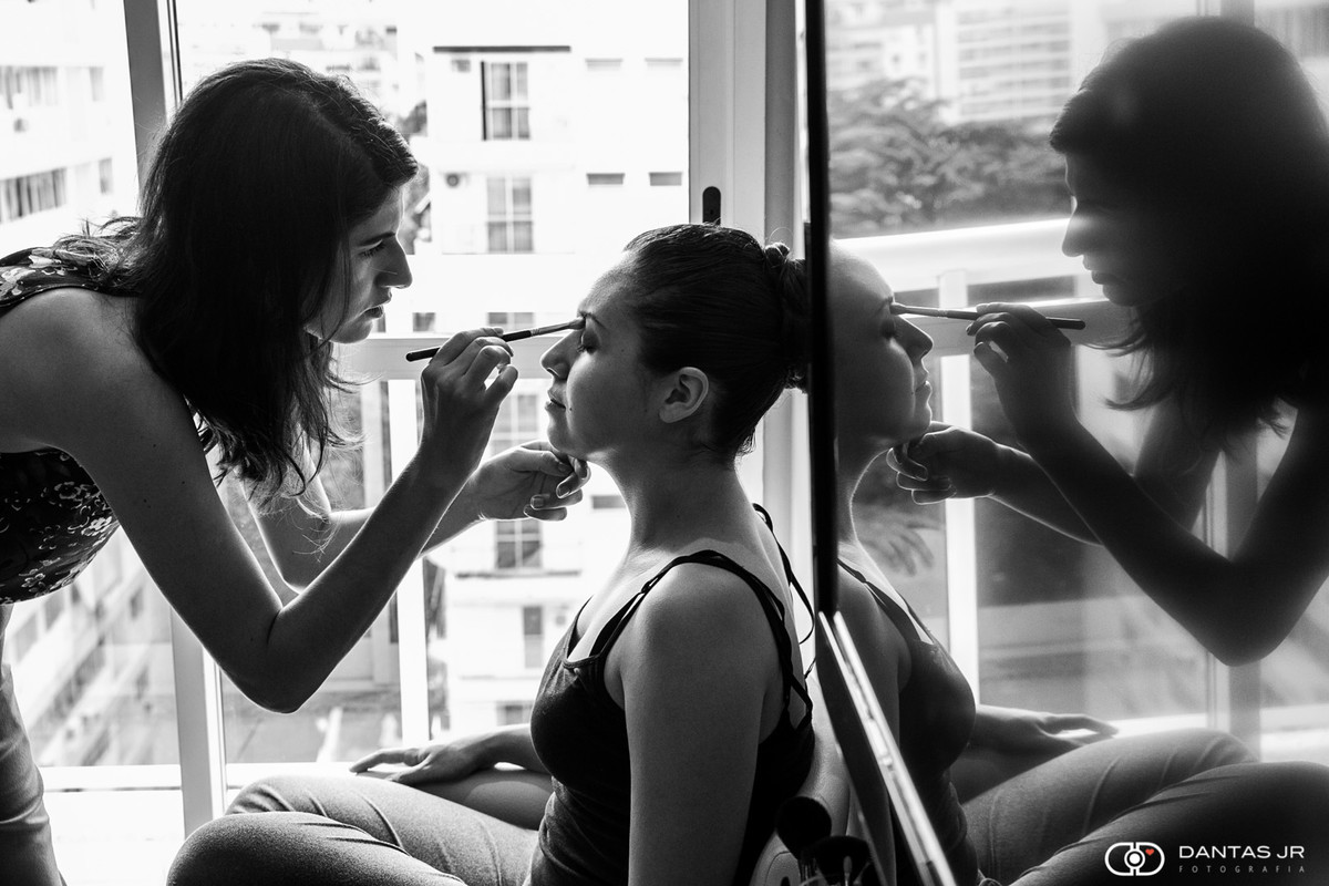 Noiva sendo maquiada com reflexo na televisão