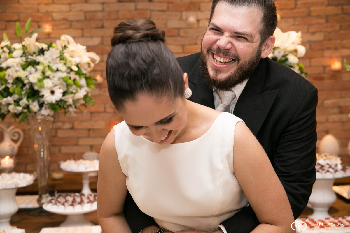 noivo abraçando noiva por trás e rindo muito