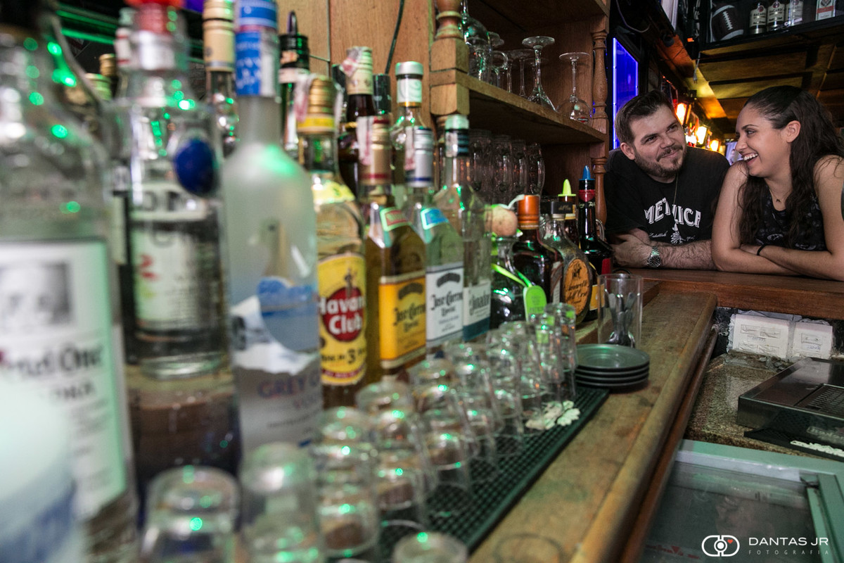 casal visto atrav;es de garrafas de tequila e vodka no Lucky Screw Irish Pub por Dantas Jr