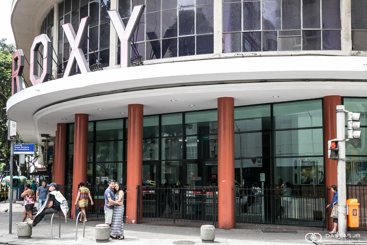 Casal de namorados se beijando na rua em frente ao cinema Roxy na Avenida Nossa Senhora de Copacabana no Rio de janeiro clicados por Dantas Jr. Fotografia