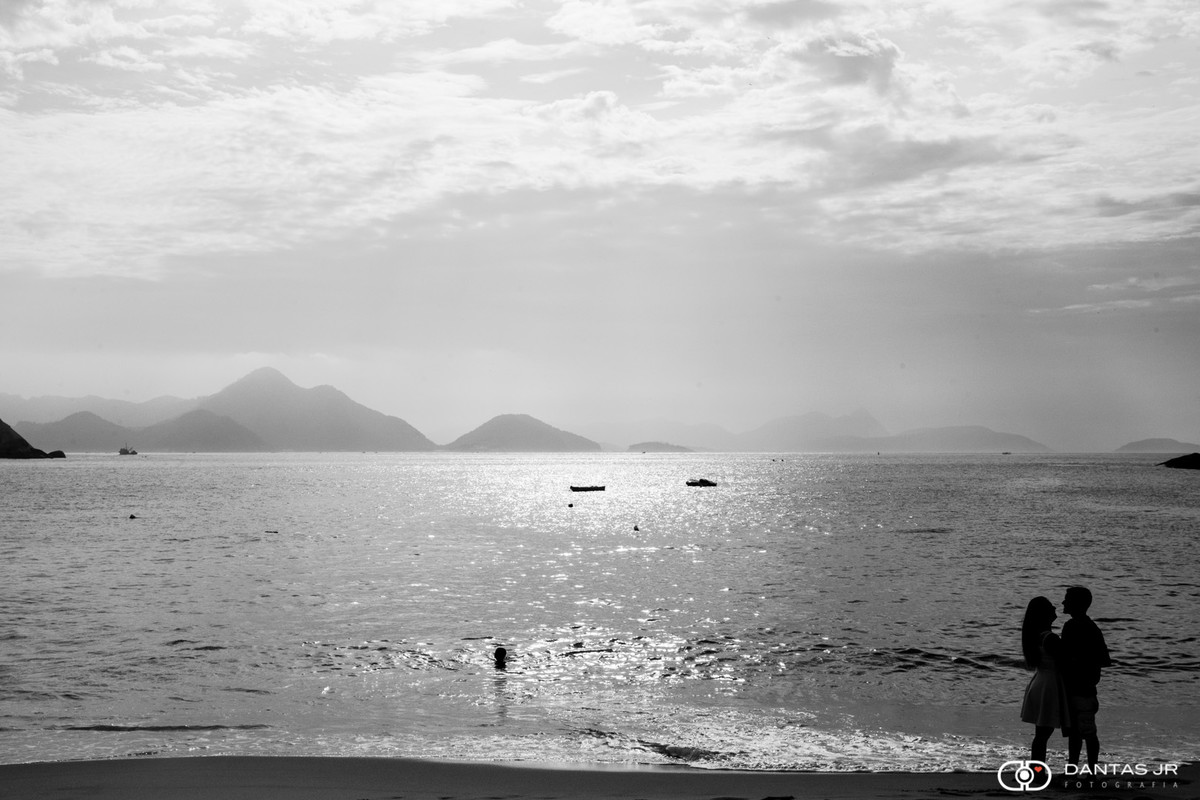 Casal em silhueta namorando em foto preto e branco em ensaio pre wedding na praia por Dantas Jr.