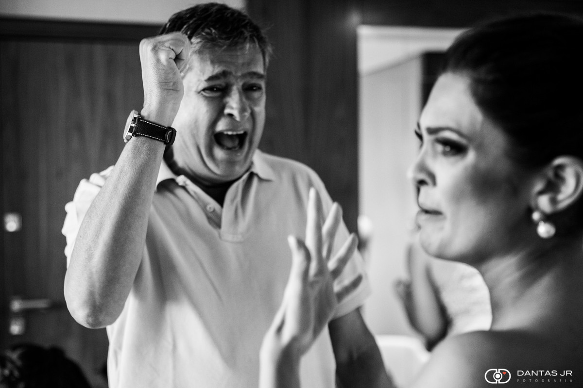 Pai da noiva emocionado e chorando vibrando muito no quarto e vendo sua filha pela primeira vez no Hotel Hilton na Barra da Tijuca por Dantas Jr. o melhor fotógrafos de casamentos do Rio de Janeiro