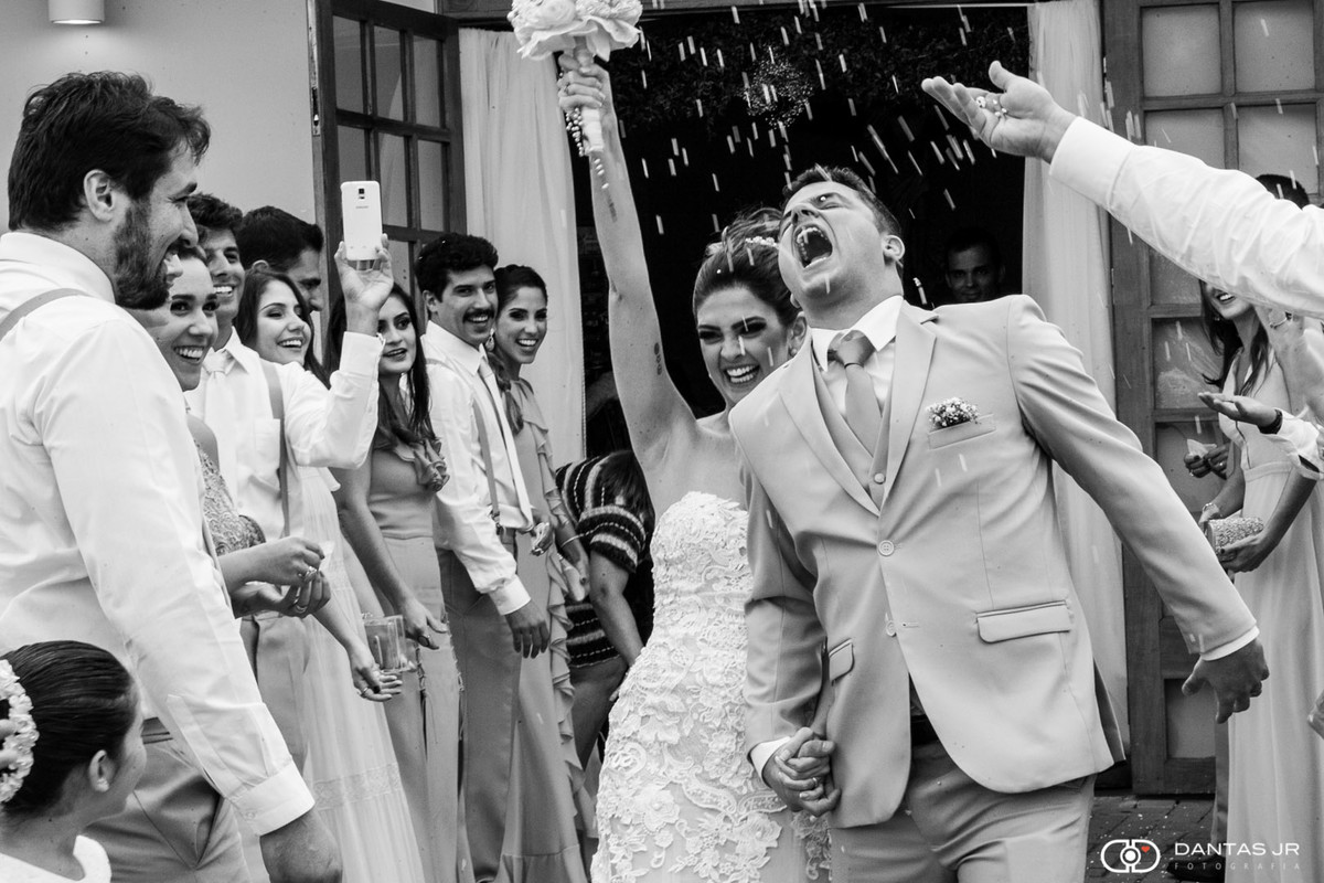 Noivos saindo da Paróqui São Marcelino Champagnat na Barra da Tijuca sob chuva de arroz por Dantas Jr.