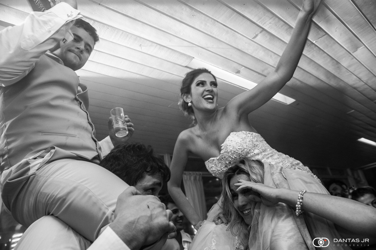 Noivos carregados nos ombros por amigos durante festa animada no Restaurante Braseiro Américas no Rio de janeiro por Dantas Jr.