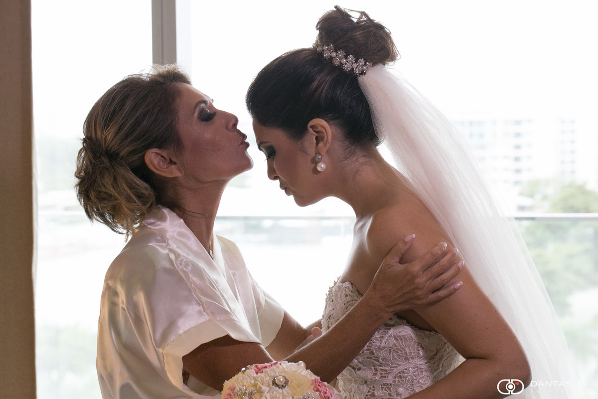 Mãe da noiva beijando testa enquanto filha se apronta no making of no Hotel Hilton na Barra da Tijuca no Rio de janeiro por Dantas Jr.