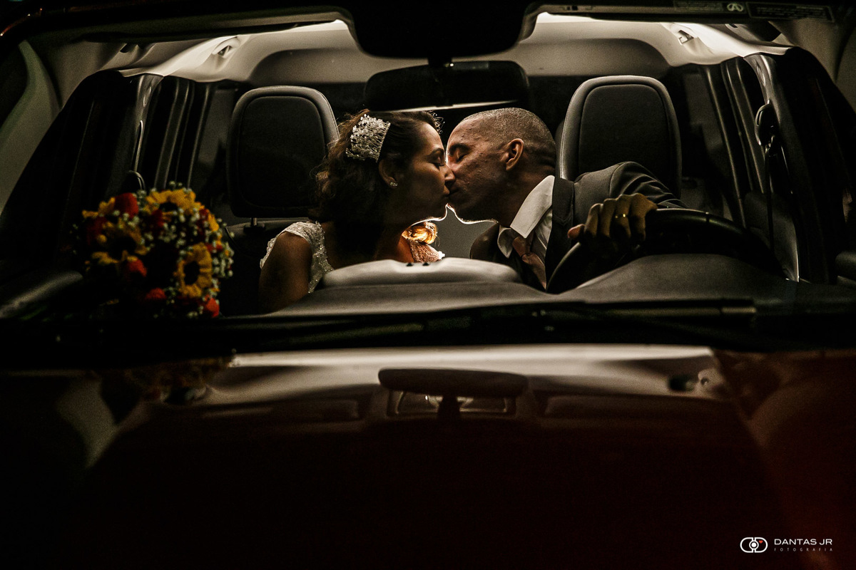 casal de noivos se beijando dentro de carro após cerimônia de casamento