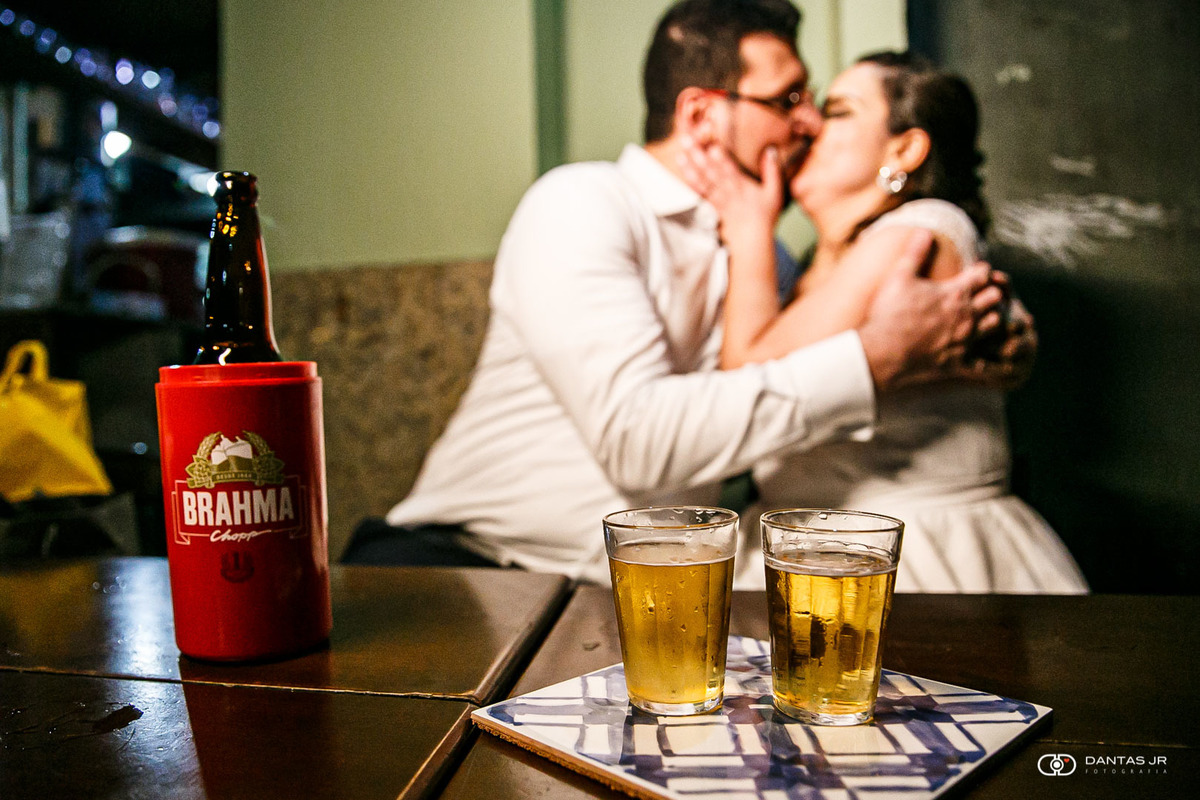 Ensaio pos wedding trash the dress com casal se beijando tomando cerveja em boteco após festa animada de mini wedding no Bistrô Ouvidor Centro do Rio de Janeiro por Dantas Jr Fotografia