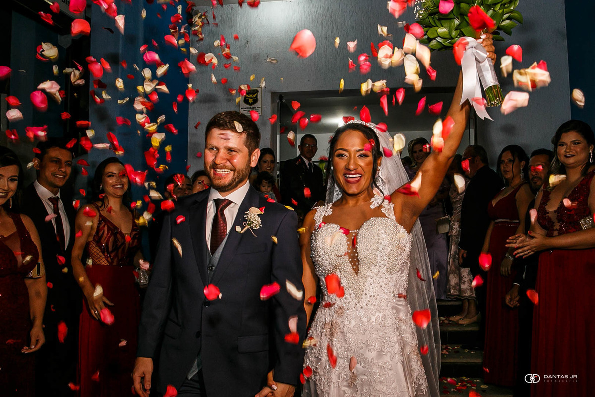 noivos sob chuva de pétalas de rosas vermelhas em sa;ida de cerimônia de casamento Destination Wedding em Três Rios por Dantas Jr. Fotografia