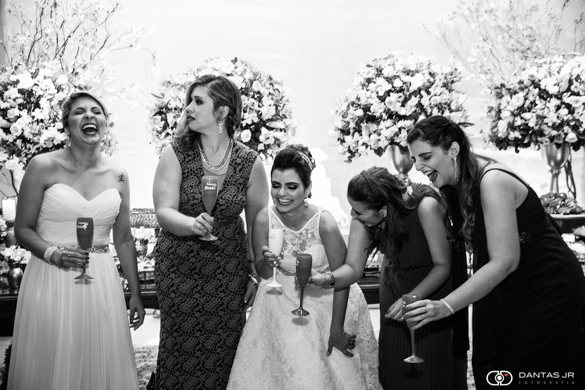 Noiva e madrinhas rindo durante brinde