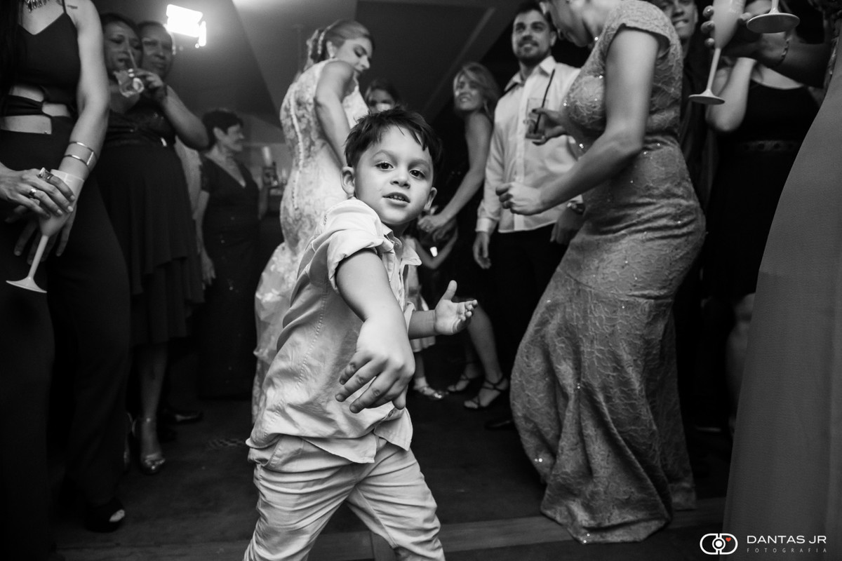 criança dançando feliz na pista do casamento com os noivos dançando ao fundo e convidados pulando juntos no Bistrô Ouvidor no Rio de janeiro no Centro por Dantas jr. Fotografia