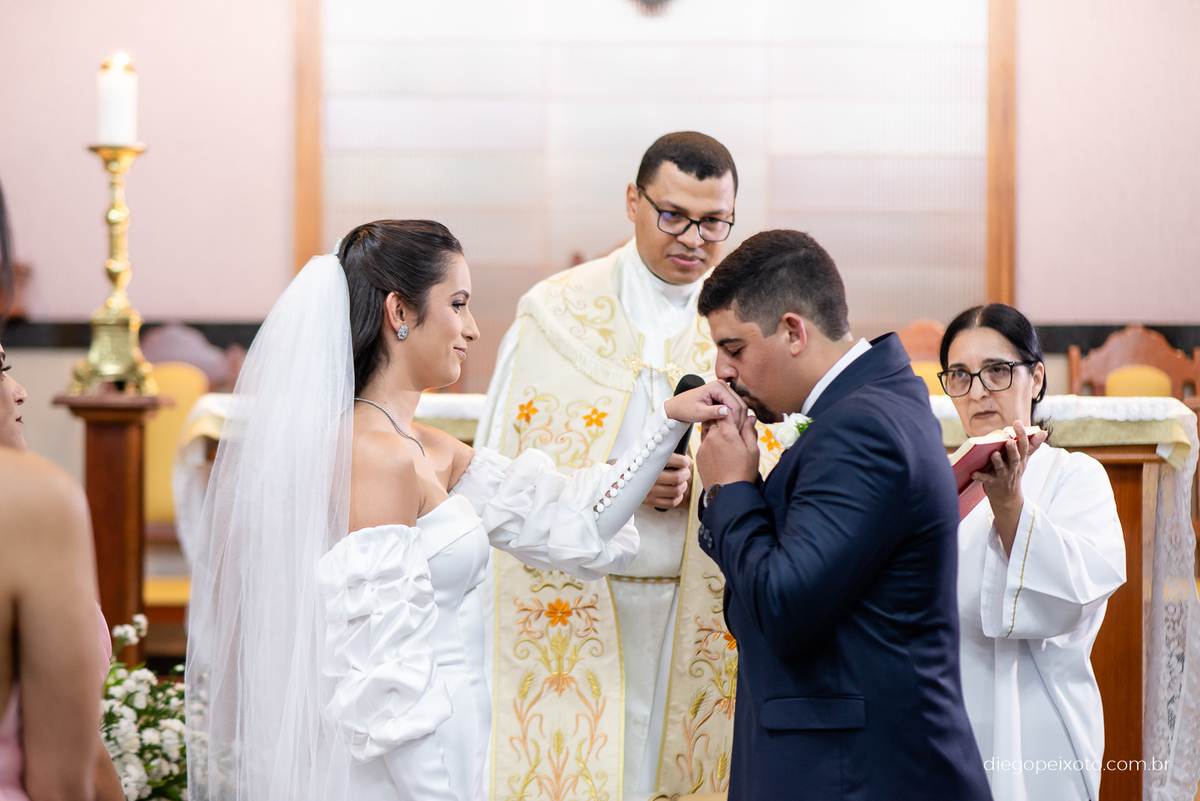 Noivo beijando a mão da noiva no casamento em caratinga