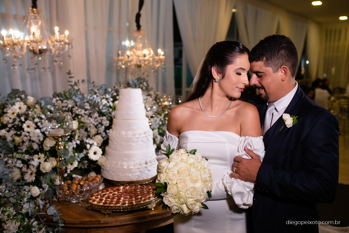 Noivos na mesa do bolo no casamento em caratinga