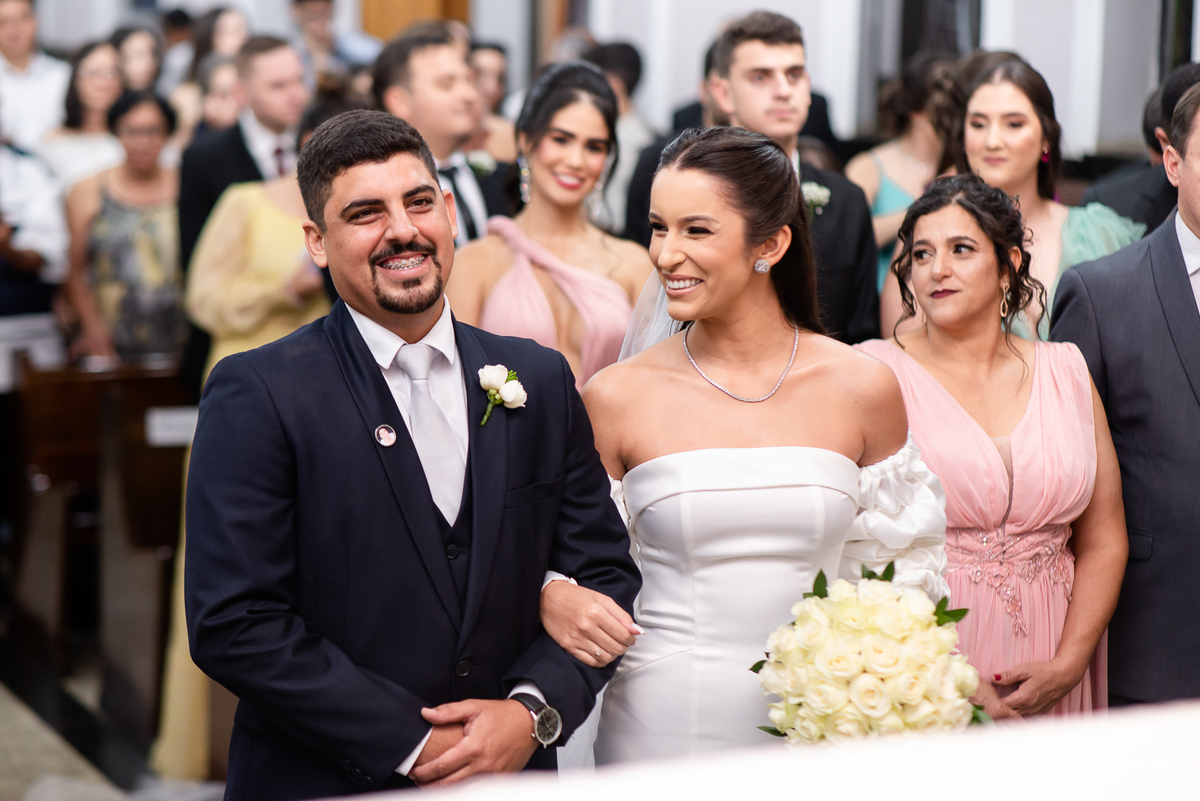 Noivos no altar sorrindo no casamento em caratinga
